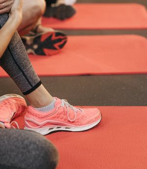Abstract shot of athletic shoes on a yoga mat.