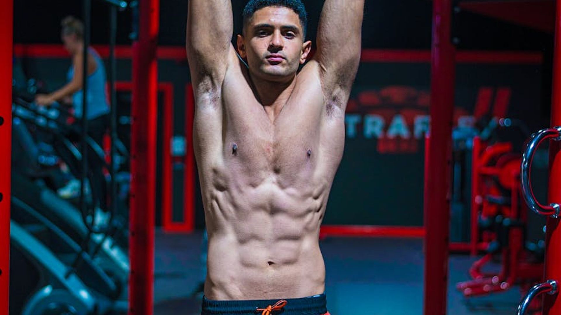 Man in a focused bodyweight exercise pose in a bright, minimalist space.