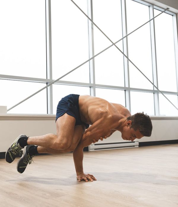 Man performing a controlled strength pose, side view.