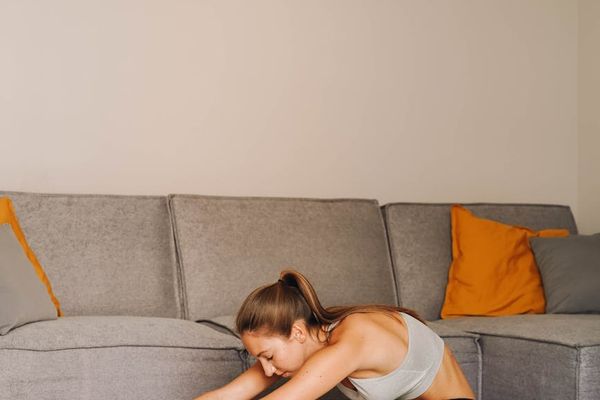 Man stretching on a mat in a calm, focused environment.